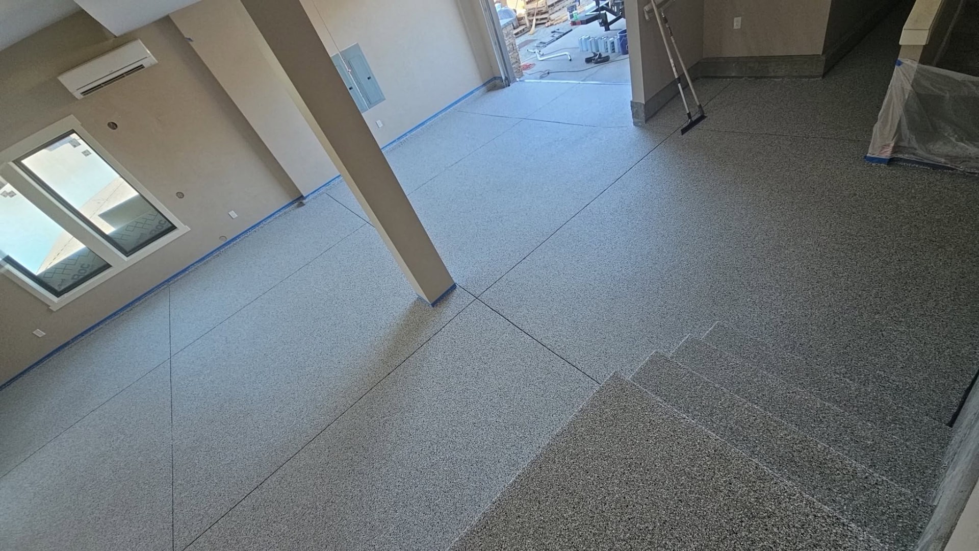 Wide gray flake epoxy floor running through a finished shop bay