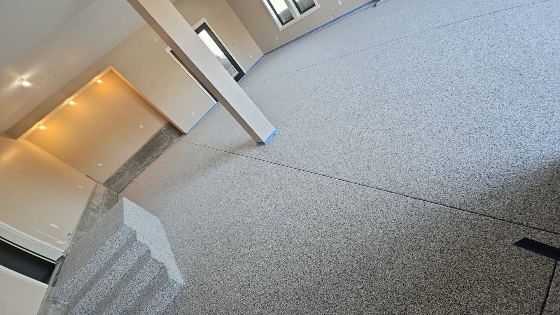 Gray flake epoxy floor and coated steps in a new garage